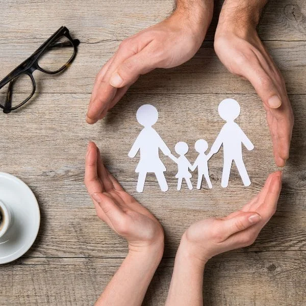 Manos rodeando una familia representado el seguro de accidentes de DKV en Logrono